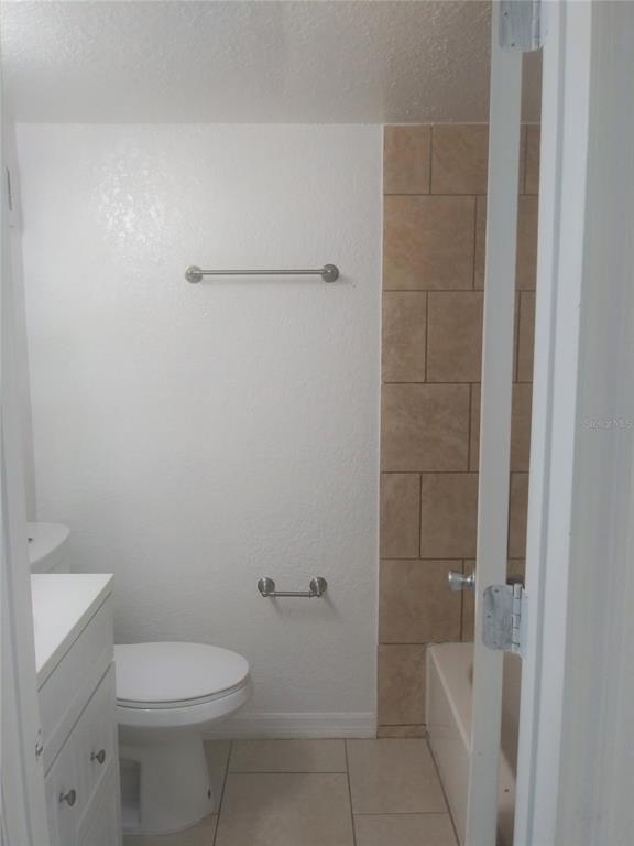 A bathroom features a white vanity, a toilet, a towel bar, and a tiled shower — 302 S SPRING GARDEN AVENUE UNIT B09, DELAND, FL
