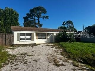 A single-story house with a gravel driveway, white siding, and a brown shingled roof — 2522 STRATFORD DRIVE, SARASOTA, FL