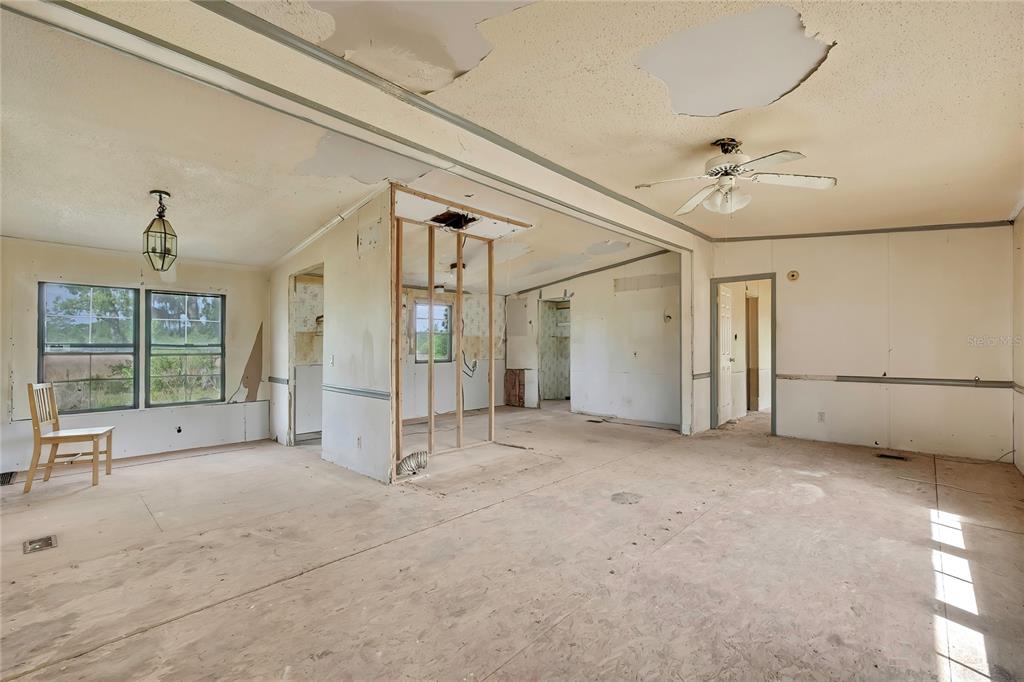 An interior view of a room under renovation with exposed wall studs and damaged ceilings — 4512 N TIMBERWOOD POINT, CRYSTAL RIVER, FL