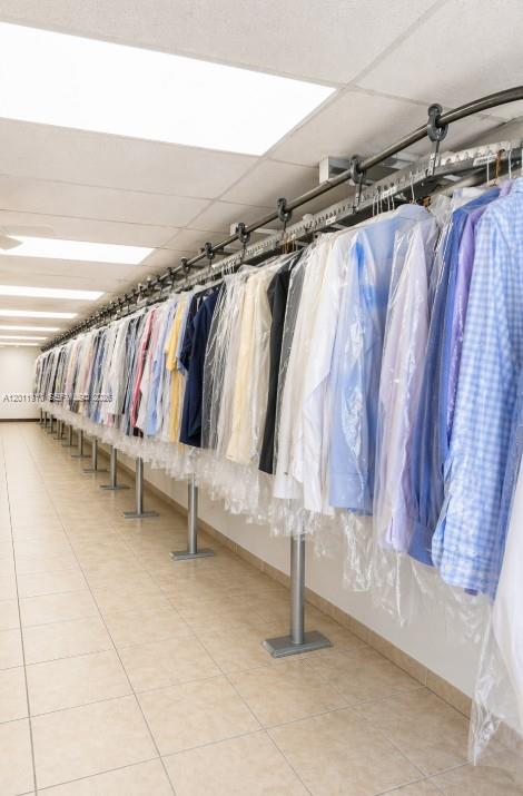 A commercial dry cleaning facility features a long motorized clothing conveyor system with hanging garments — 10114 S Military Trl, Boynton Beach FL 33436, BOYNTON BEACH, FL