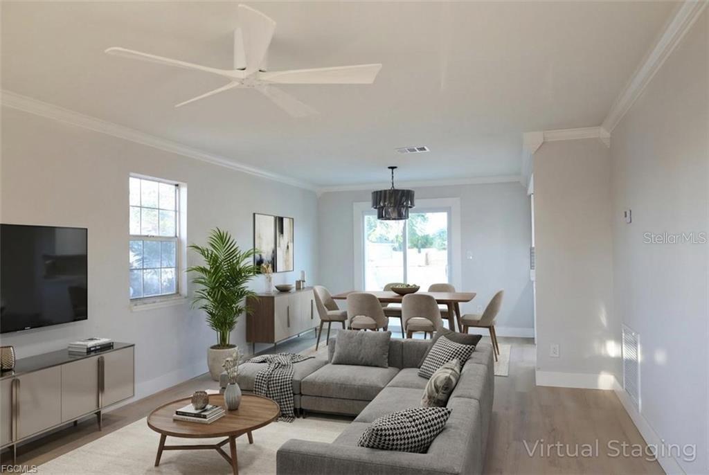 A living and dining room with light walls, wood-look flooring, and modern furniture — 3906 28TH STREET SW, LEHIGH ACRES, FL