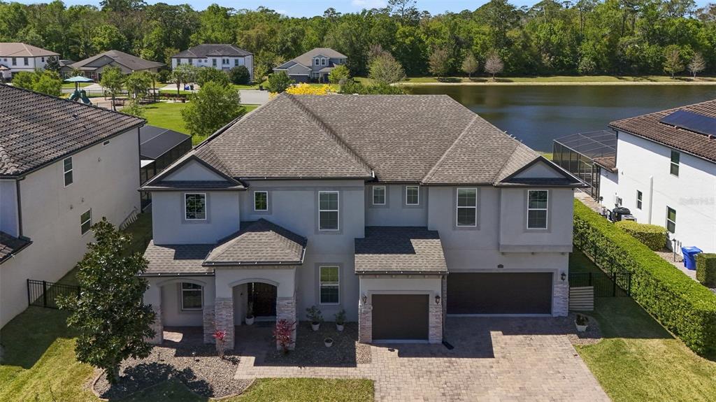 An aerial view of a two-story suburban house with a paved driveway and lake view — 1250 RED HAVEN LANE, OVIEDO, FL