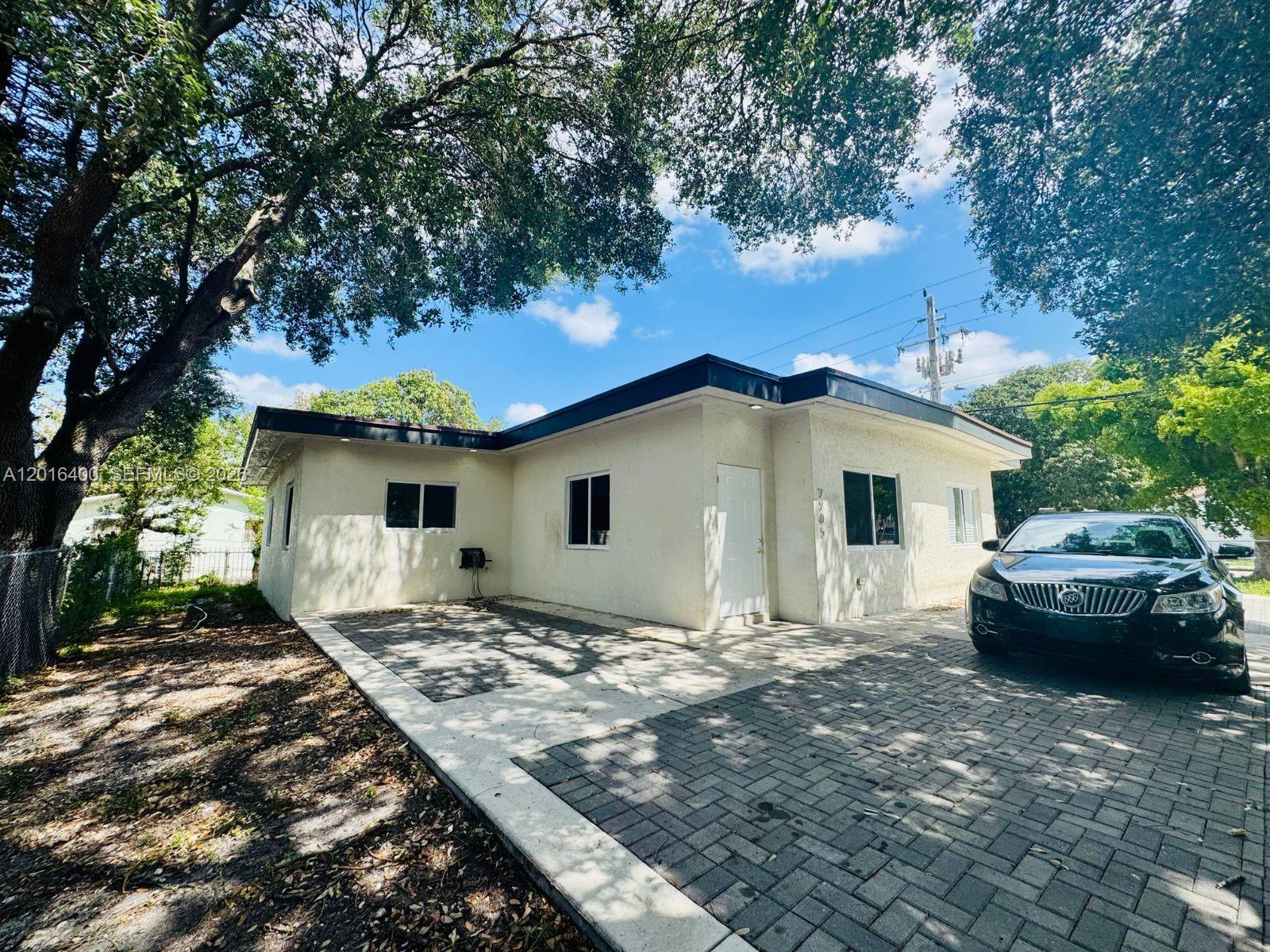 A single-story white stucco house with a paved driveway and a large tree — 7703 NW 3rd Ave, Miami FL 33150, MIAMI, FL