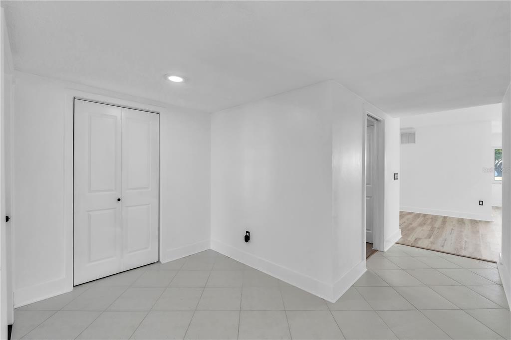 A bright room with white walls, gray tile flooring, and a white double-door closet — 6522 11TH AVENUE W, BRADENTON, FL