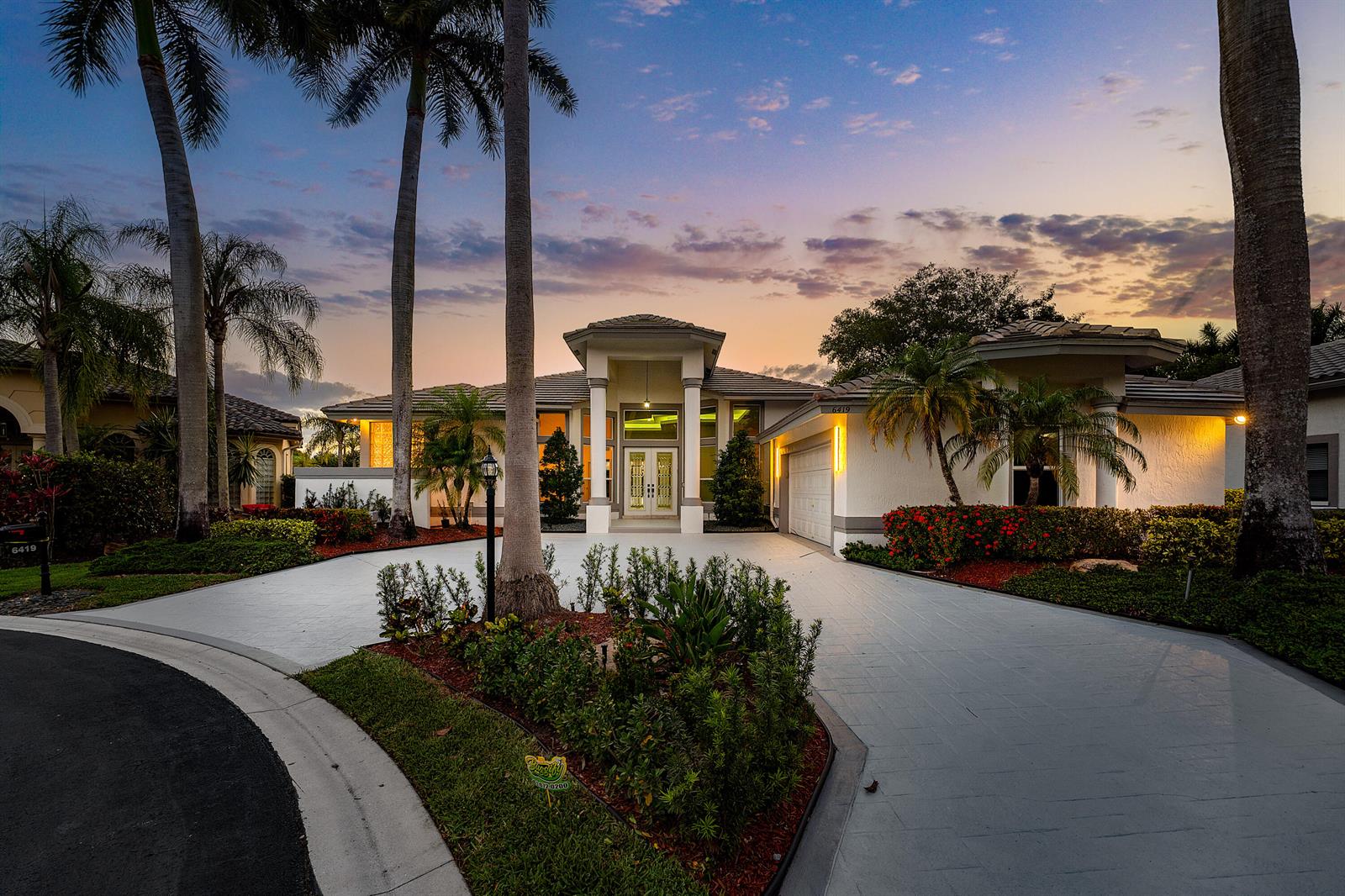 A single-story house with a white facade, a two-car garage, and tall palm trees — 6419 NW 99th Drive, Parkland FL 33076, PARKLAND, FL