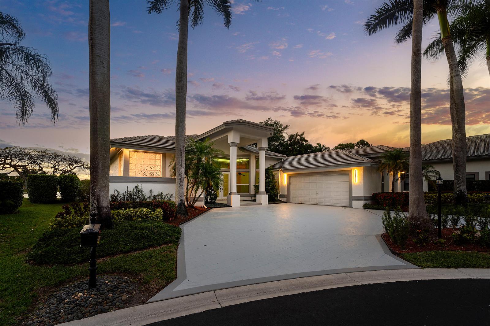 A swimming pool with a screened enclosure overlooks a lake at sunset — 6419 NW 99th Drive, Parkland FL 33076, PARKLAND, FL