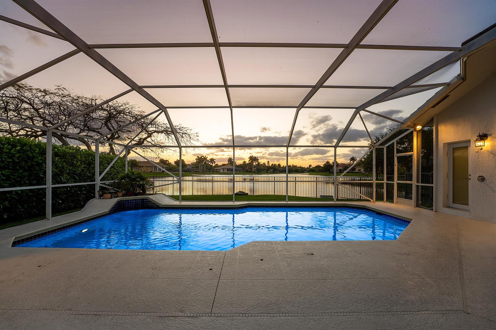 A sunset view over a lake with houses and palm trees in the background — 6419 NW 99th Drive, Parkland FL 33076, PARKLAND, FL