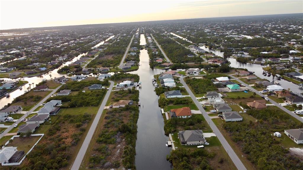 An aerial view shows houses lining a canal in a residential neighborhood — 10281 ST PAUL DRIVE, PORT CHARLOTTE, FL