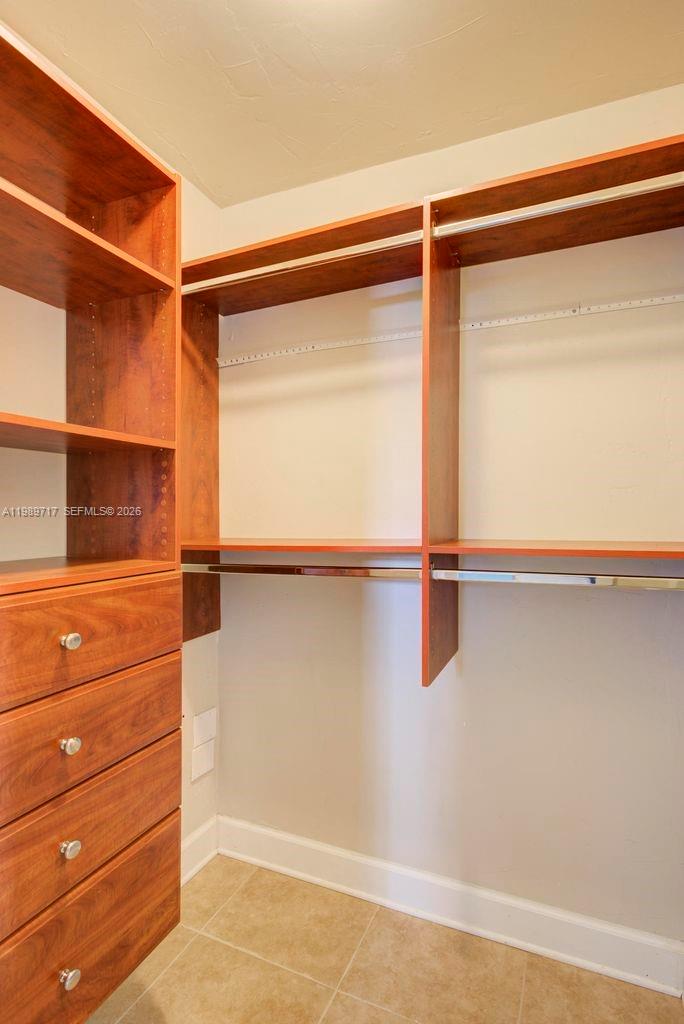 A walk-in closet features wood shelving, a built-in dresser, and a hanging rod — 2311 Patterson ave, Key West FL 33040, KEY WEST, FL