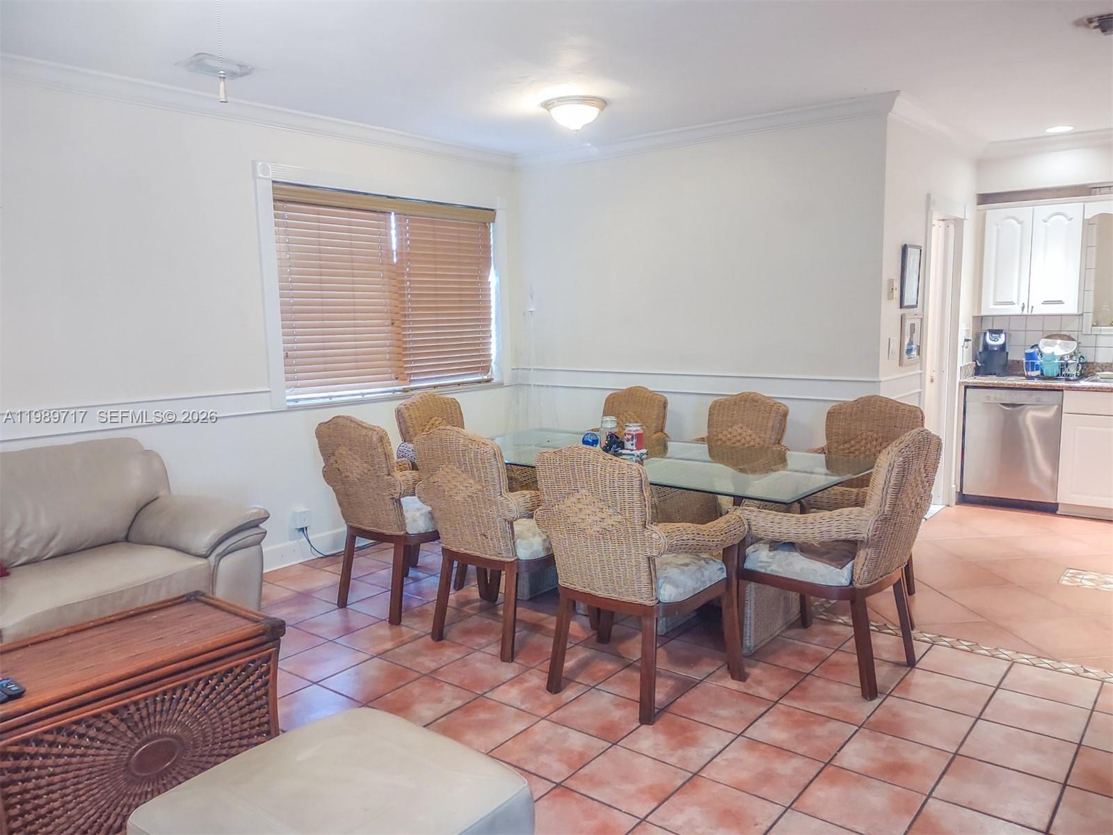 A dining area features a glass-top table with wicker chairs on a tiled floor — 2311 Patterson ave, Key West FL 33040, KEY WEST, FL