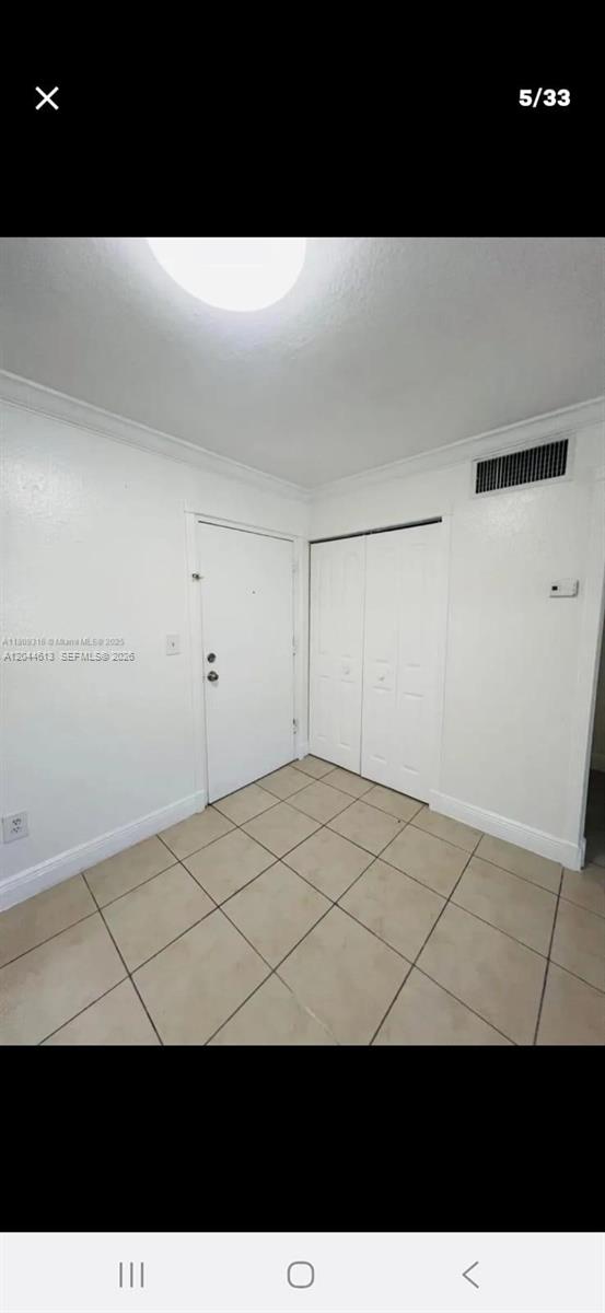A room with white walls, tile flooring, a single door, and a white closet — 735 SULTAN AVE # 1, Opa-Locka FL 33054, OPA-LOCKA, FL