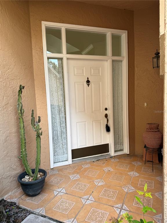 A front entryway features a white door with sidelights, a transom window, and tiled flooring — 14300 DULCIMER COURT, ORLANDO, FL