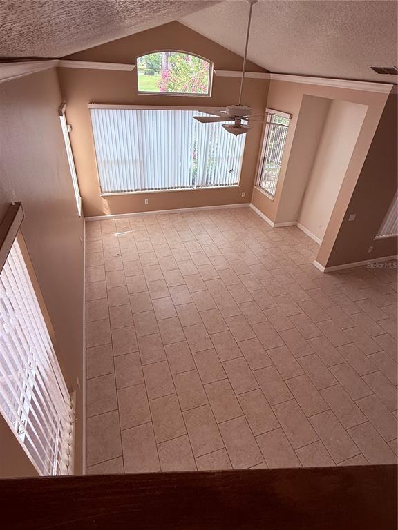 A high-angle view of a living room with vaulted ceilings, tile floors, and large windows — 14300 DULCIMER COURT, ORLANDO, FL
