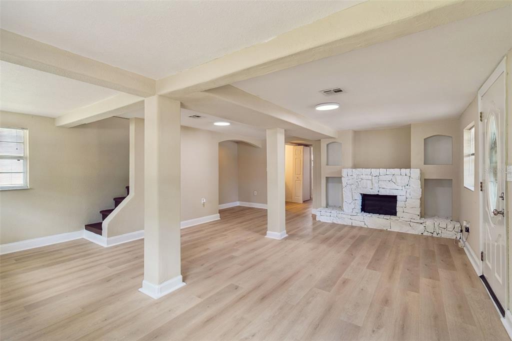A two-story house with beige siding, a covered front entryway, and a white picket fence — 11945 WANDA AVENUE, NEW PORT RICHEY, FL