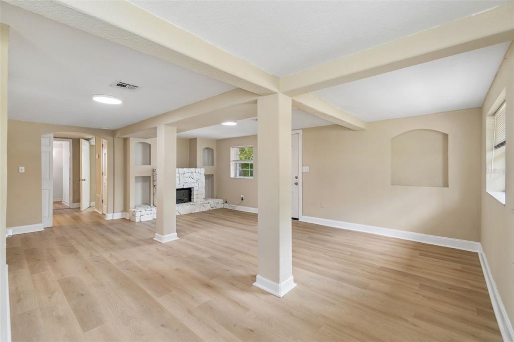 A covered porch with a white railing, stone wall, and glass doors overlooking a yard — 11945 WANDA AVENUE, NEW PORT RICHEY, FL