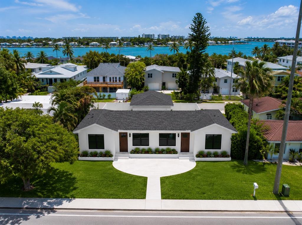 An aerial view shows a white single-story house with a dark roof and lawn — 3219 E DEBAZAN AVENUE, ST PETE BEACH, FL