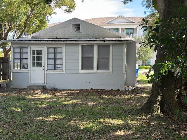 A small, light-gray, single-story house with a white door and multiple windows — 1010 ROSERY ROAD NW, LARGO, FL
