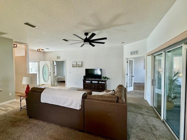A living room features a brown sectional sofa, a television on a console, and sliding doors — 2360 NW 53RD AVENUE ROAD, OCALA, FL