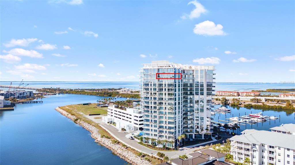 An aerial view shows a high-rise condominium building near a waterfront with a red rectangle highlighting a balcony — 5120 MARINA WAY UNIT 16005, TAMPA, FL