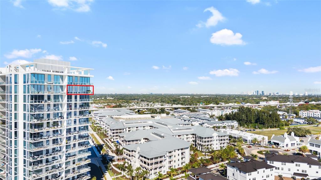 An aerial view shows a high-rise building with a red-outlined balcony overlooking a suburban landscape — 5120 MARINA WAY UNIT 16005, TAMPA, FL