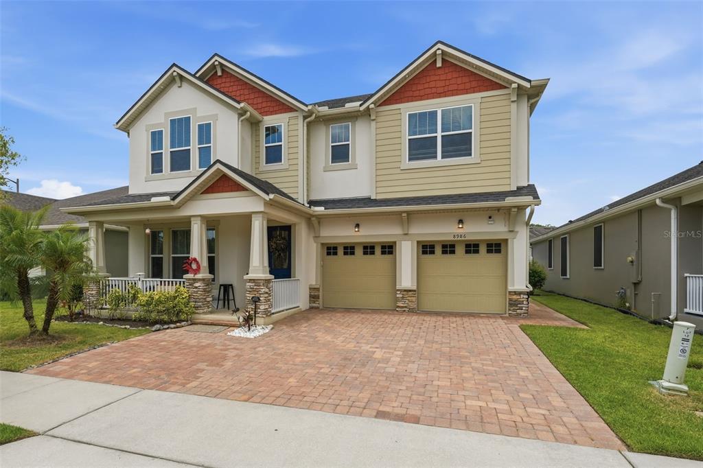 A two-story house with a brick paver driveway, two-car garage, and a covered front porch — 8986 FULLERWOOD AVENUE, ORLANDO, FL