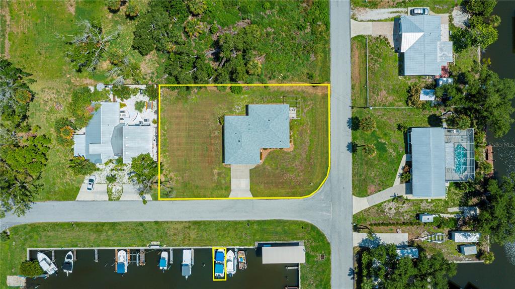An aerial view shows a house with a blue roof on a corner lot — 8152 SEASHELL STREET, ENGLEWOOD, FL