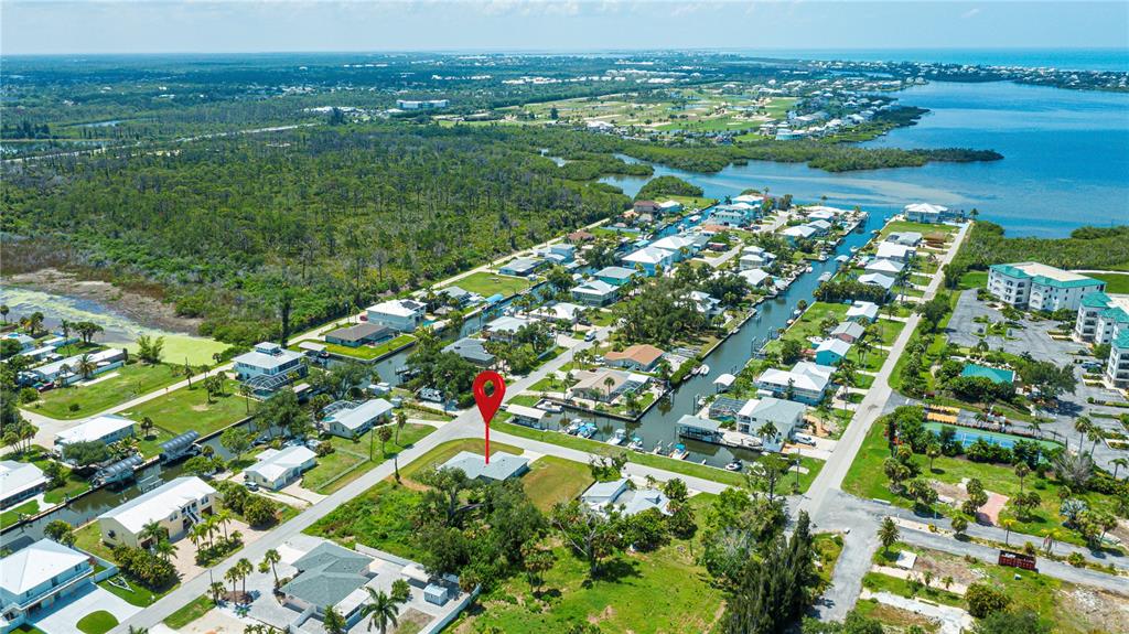 An aerial view shows a residential neighborhood with houses, canals, and a red location pin — 8152 SEASHELL STREET, ENGLEWOOD, FL