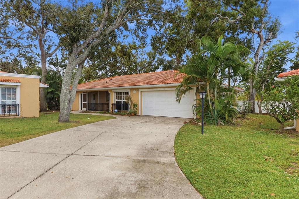 A single-story house with a white garage door, orange tile roof, and a concrete driveway — 131 49TH COURT E, PALMETTO, FL