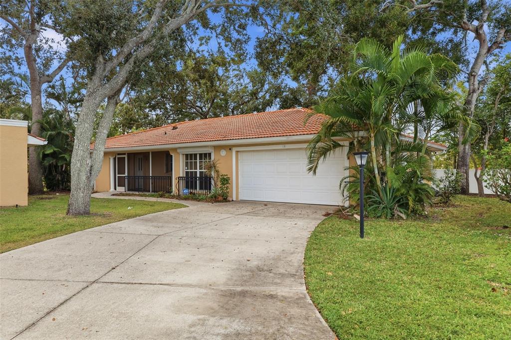 A single-story house with a terracotta tile roof, white garage door, and a concrete driveway — 131 49TH COURT E, PALMETTO, FL