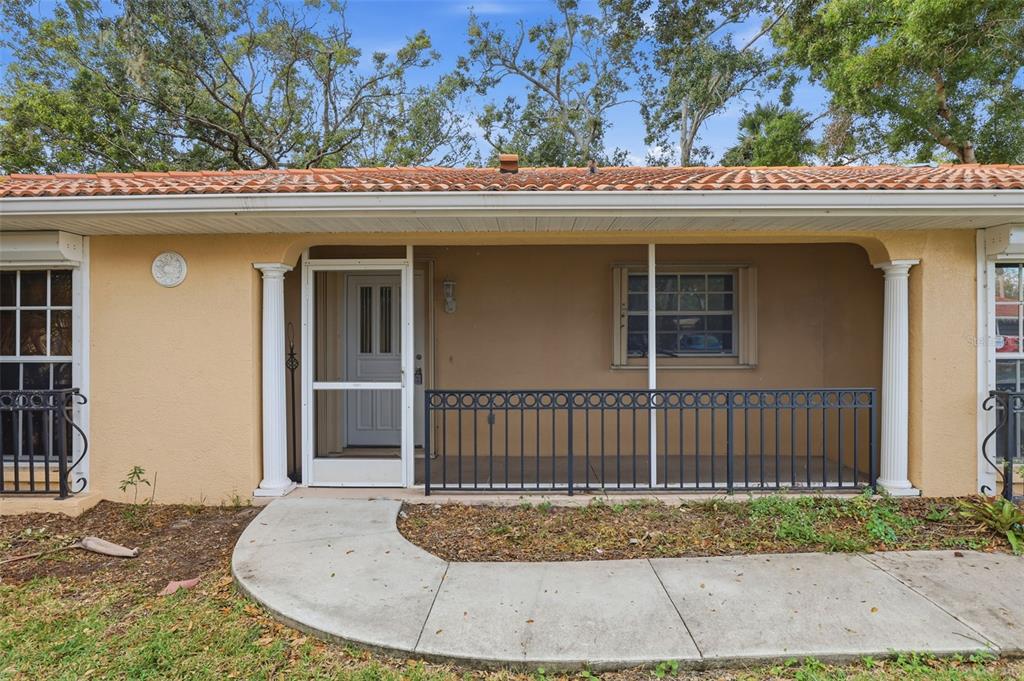 A single-story house exterior features a covered porch with a metal railing and white columns — 131 49TH COURT E, PALMETTO, FL