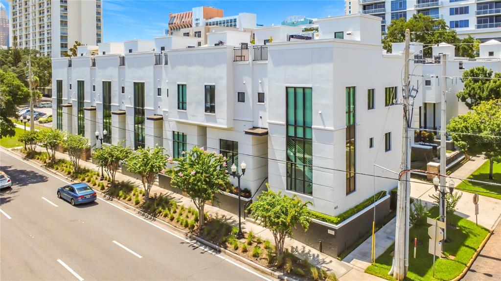An exterior view of a modern white multi-story townhouse complex with large vertical windows — 465 E SOUTH STREET UNIT 6, ORLANDO, FL