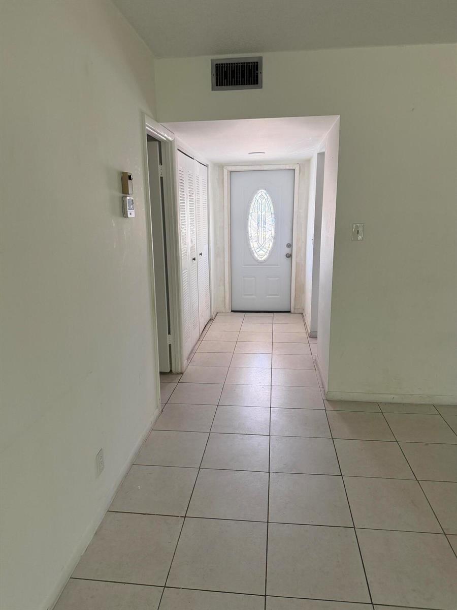 A tiled entryway features a white front door with a decorative oval glass insert — 7205 W Atlantic Boulevard, Margate FL 33063, MARGATE, FL