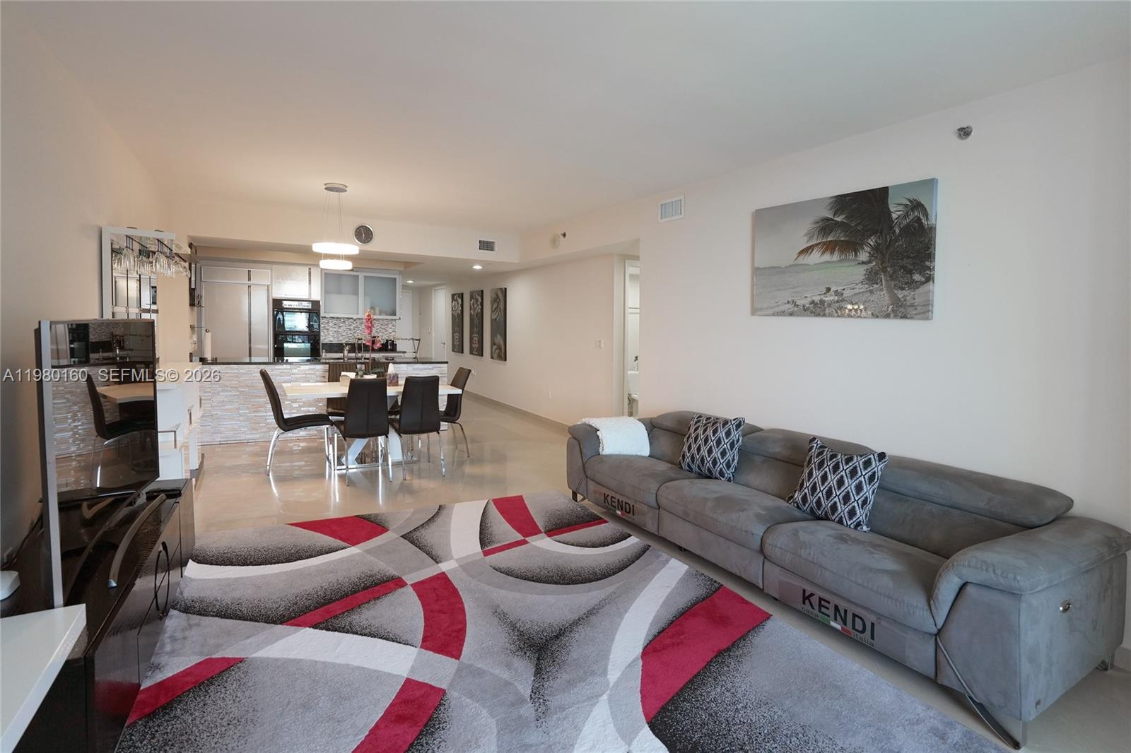 A living room and dining area feature a grey sofa, patterned rug, and open kitchen — 1830 S Ocean Dr # 4111, Hallandale Beach FL 33009, HALLANDALE BEACH, FL