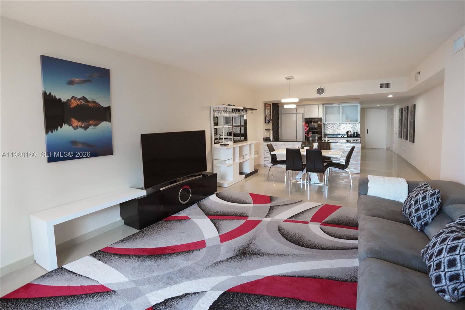 A living room features a patterned area rug, a television console, and an open kitchen — 1830 S Ocean Dr # 4111, Hallandale Beach FL 33009, HALLANDALE BEACH, FL