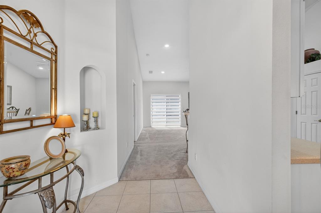 A tiled entryway leads to a carpeted living area with a decorative arched wall niche — 5466 WARD LAKE DRIVE, PORT ORANGE, FL
