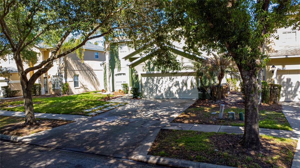 A two-story suburban house with a two-car garage and a concrete driveway — 8032 ACADIA ESTATES COURT, KISSIMMEE, FL
