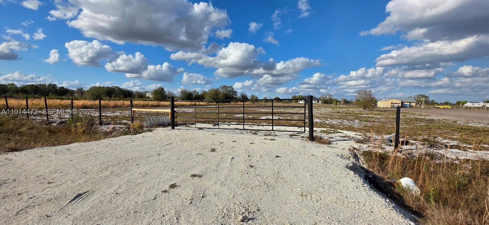 A metal gate secures the entrance to a large, flat, undeveloped dirt lot — 16525 NW 260 st, Okeechobee FL 34972, OKEECHOBEE, FL