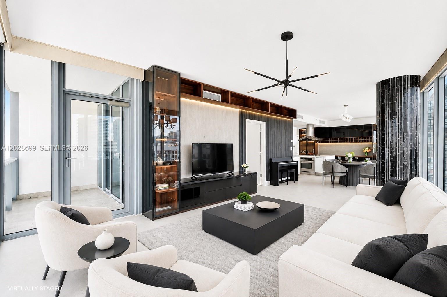 A modern living room features a black media console, white sofa, and a black chandelier — 601 NE 36th St # 1101, Miami FL 33137, MIAMI, FL