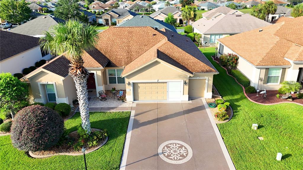 An aerial view shows a suburban house with a brown roof, driveway, and palm tree — 11735 SE 91ST CIRCLE, SUMMERFIELD, FL