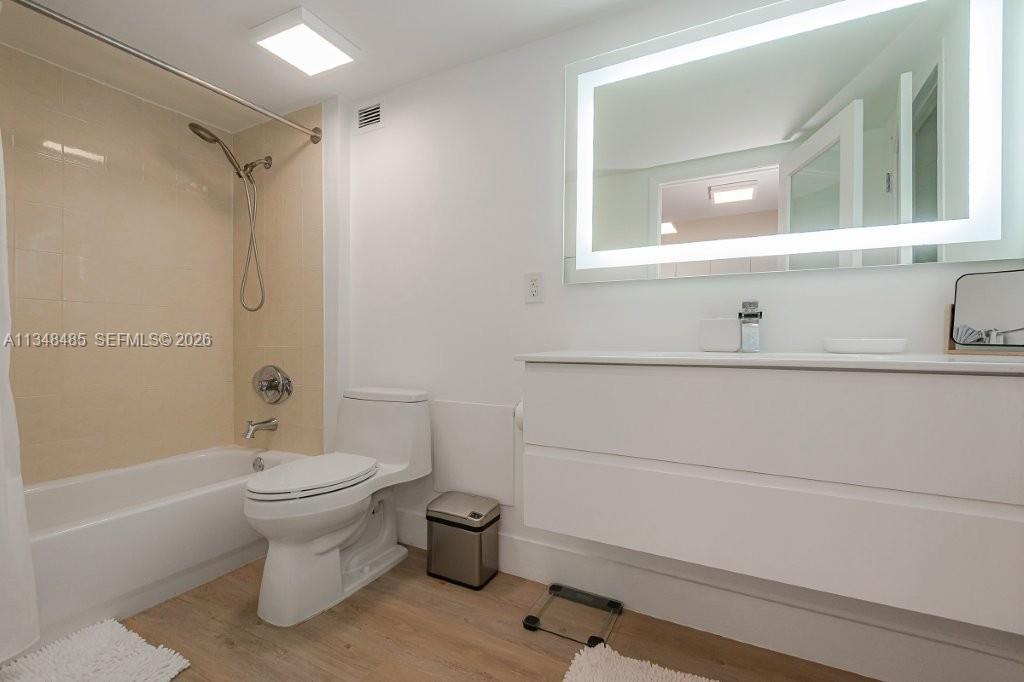 A bathroom features a white vanity, a lighted mirror, a toilet, and a shower-tub combo — 2301 Collins Ave # 927, Miami Beach FL 33139, MIAMI BEACH, FL