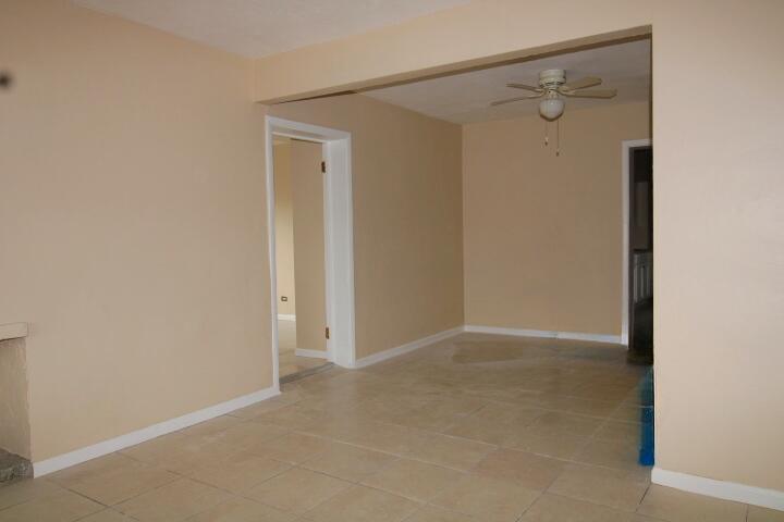 An interior view of a room with beige walls, tile flooring, and a ceiling fan — 1417 W 32nd Street, Riviera Beach FL 33404, RIVIERA BEACH, FL