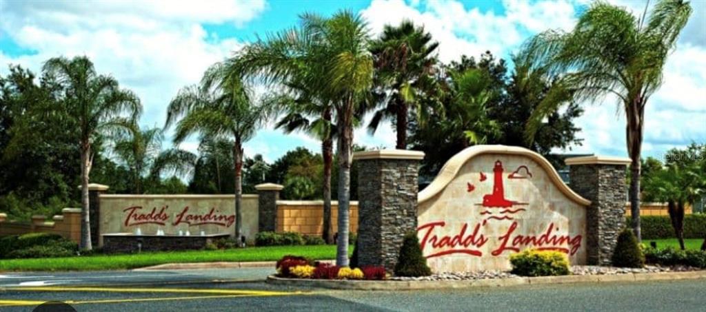 The entrance sign for Tradds Landing features a stone monument with a lighthouse logo — 4916 CAPE HATTERAS DRIVE, CLERMONT, FL