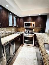 A kitchen features dark wood cabinets, granite countertops, a stainless steel oven, and a wine cooler — 800 N Miami Ave # 1501, Miami FL 33130, MIAMI, FL