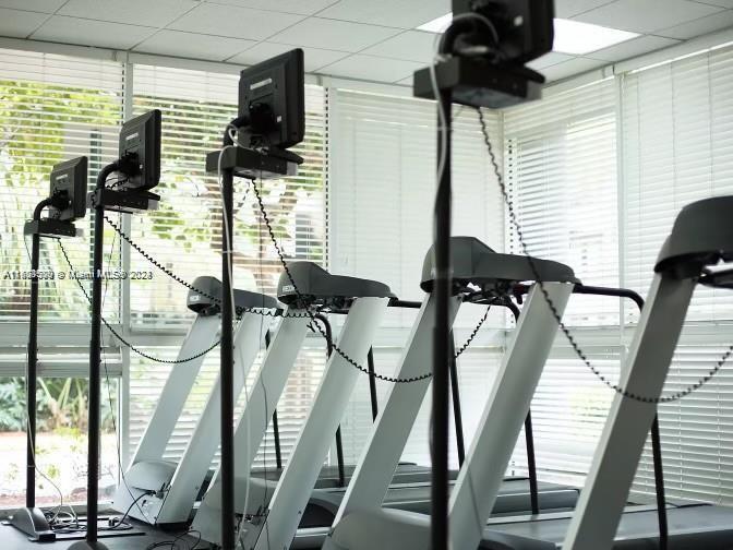A row of treadmills with attached monitors stands in a gym with window blinds — 800 N Miami Ave # 1501, Miami FL 33130, MIAMI, FL