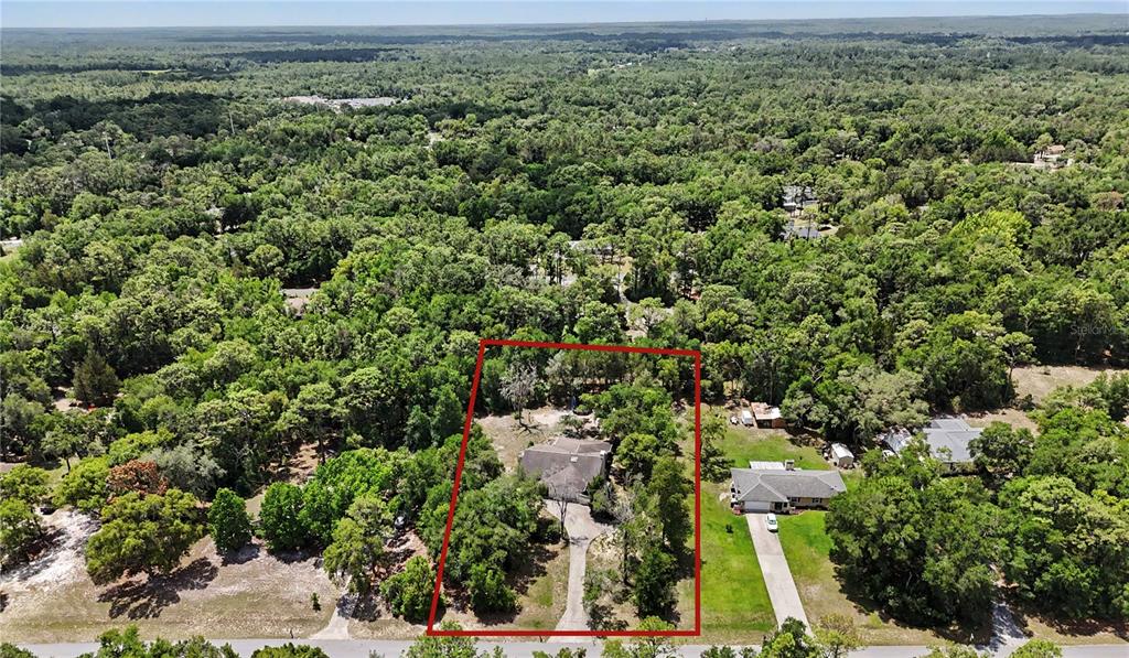 An aerial view shows a house with a long driveway surrounded by dense forest — 20250 SW 93 LANE ROAD, DUNNELLON, FL