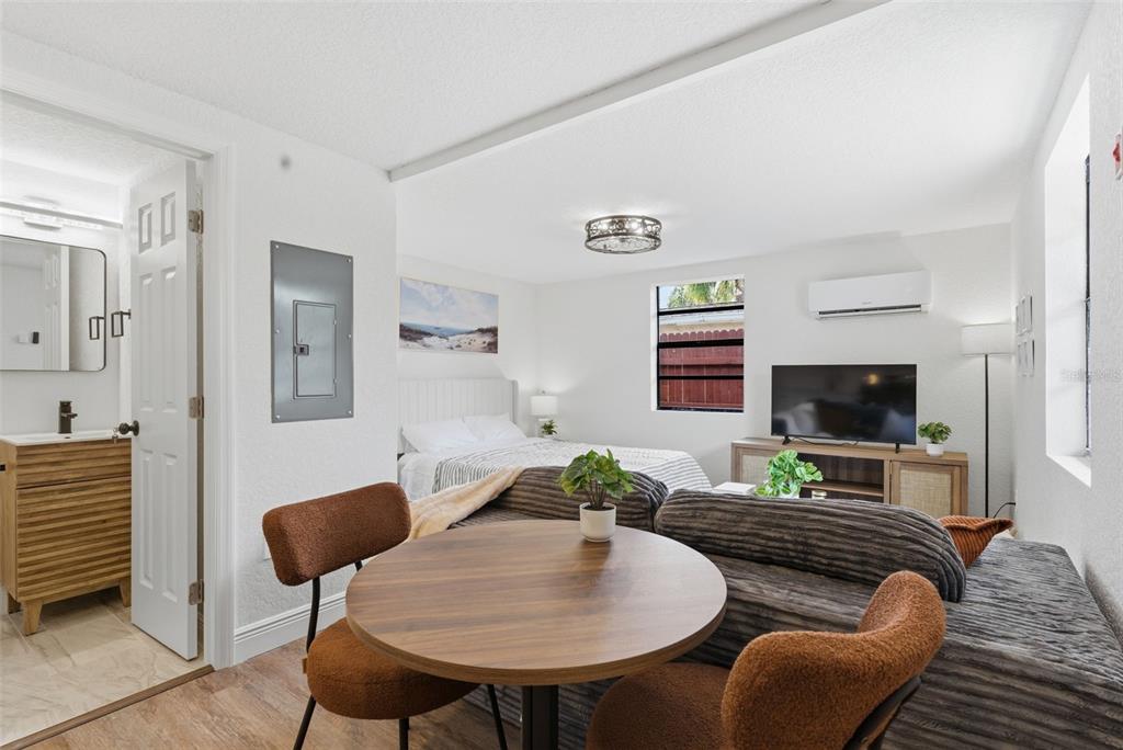 A studio apartment features a dining table, a sofa, a bed, and an attached bathroom — 113 145TH AVENUE E UNIT 4, MADEIRA BEACH, FL