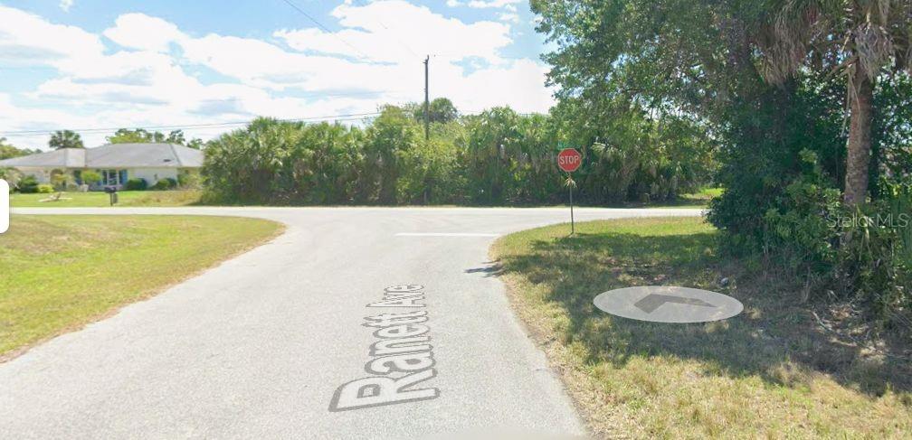 A paved road intersection features a stop sign and surrounding trees and vegetation — 488 MCCABE STREET, PORT CHARLOTTE, FL