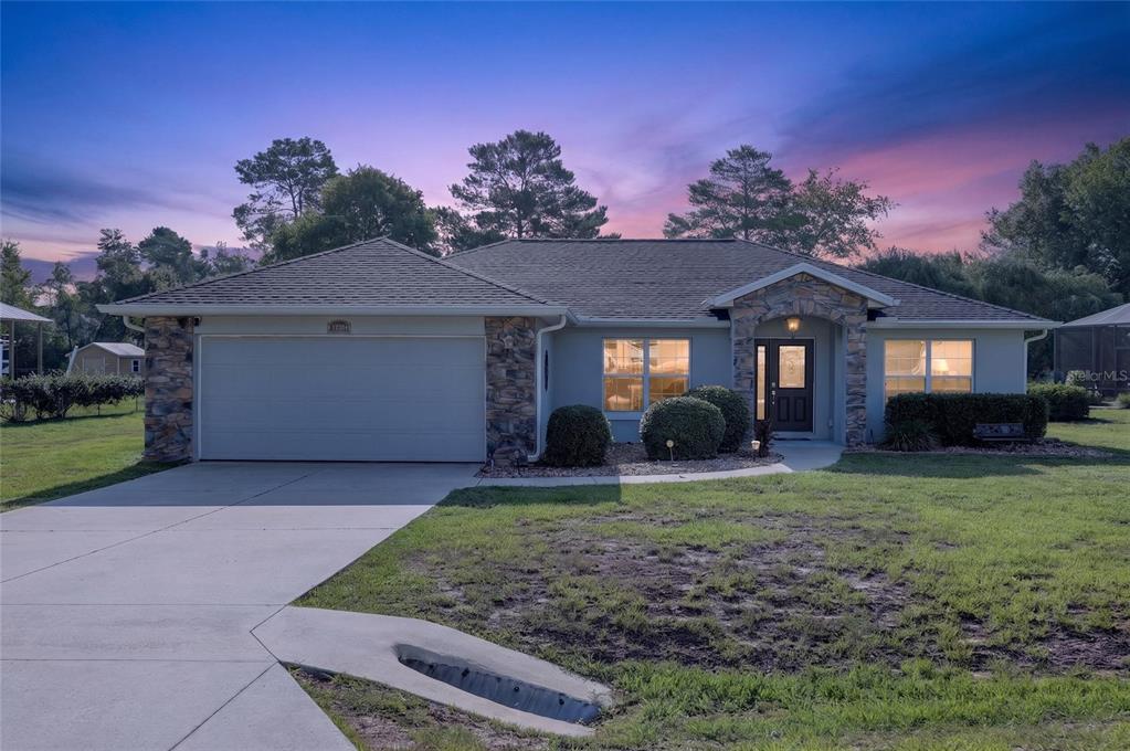 A single-story house with a stone-accented facade, a two-car garage, and a concrete driveway — 9583 SW 46TH TERRACE, OCALA, FL