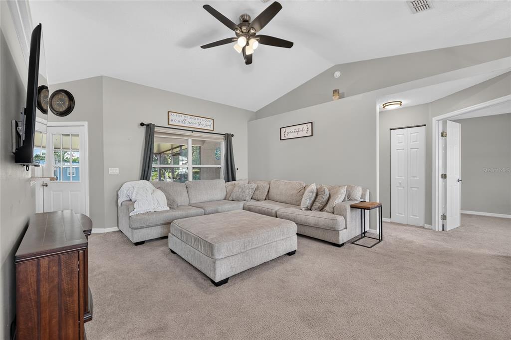 A living room features a large sectional sofa, a central ottoman, and a ceiling fan — 9583 SW 46TH TERRACE, OCALA, FL