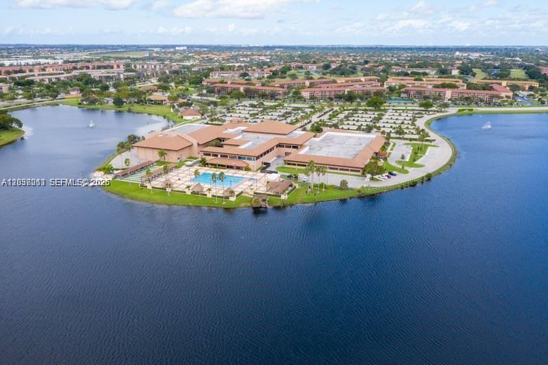 An aerial view shows a large building complex with a swimming pool surrounded by water — PEMBROKE PINES, FL